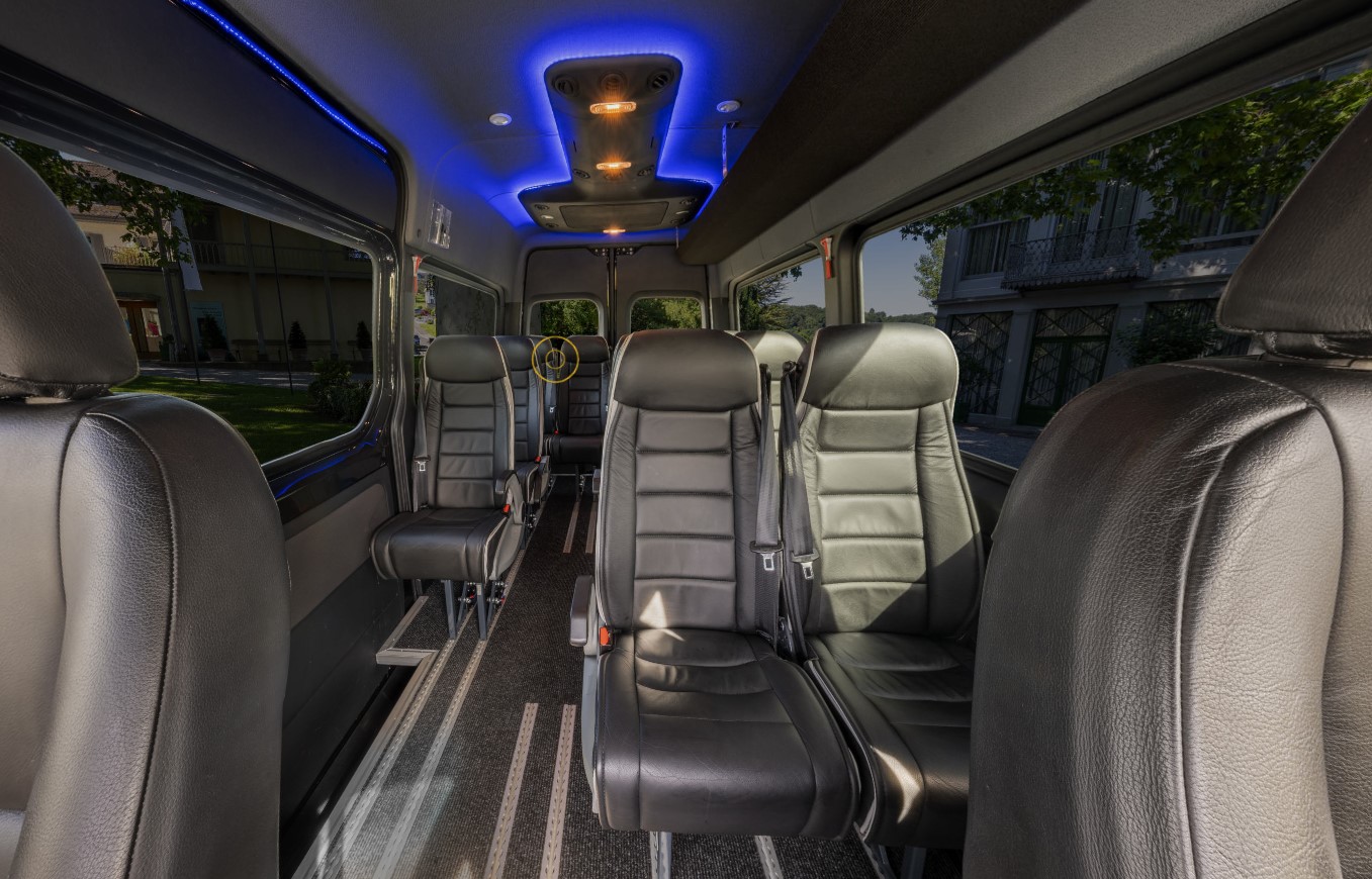 Mercedes corporate van interior with black leather passenger seating and blue accent lighting