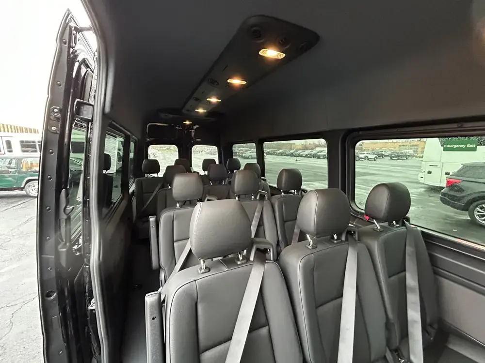 Mercedes corporate van interior with gray passenger seats and aisle view