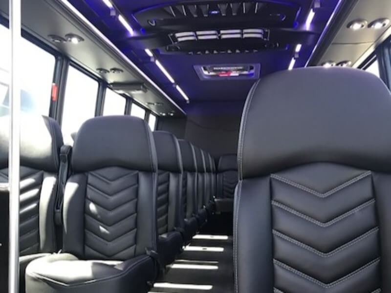 20 passenger shuttle bus interior with black leather seats and blue LED ceiling lighting